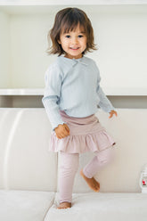 Toddler girl wearing Avauma powder pink ruffle skirt leggings and light blue ribbed top – soft baby clothing outfit